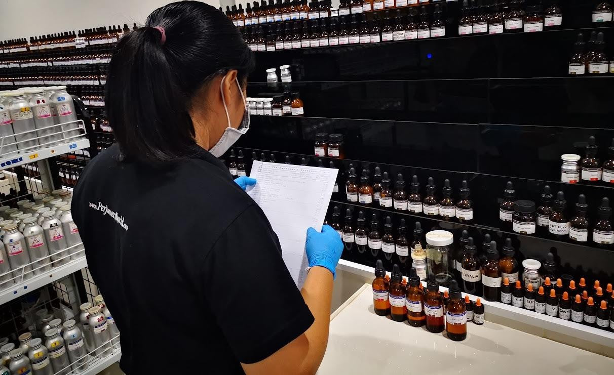 A PerfumersWorld team member working with labelled fragrance materials